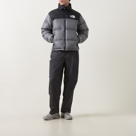 Model wearing North Face casual jacket in smoked pearl and TNF black, styled with dark trousers and grey trainers.