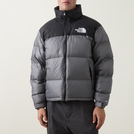 Model wearing The North Face casual jacket in smoked pearl and TNF black, puffer style with zip fastening and ribbed collar.