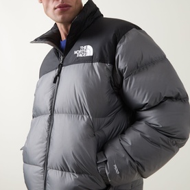 Model wearing The North Face casual jacket in Smoked Pearl and TNF Black, with quilted puffer panels and contrast yoke detail.