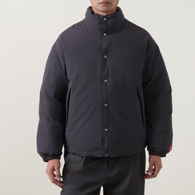 Model wearing North Face Casual Jacket in Obsidian, featuring a stand collar, snap button fastening, and a quilted puffer silhouette.