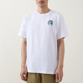 Model wearing North Face Crew Neck T in TNF White with small Pacific Teal chest logo graphic, styled with khaki trousers