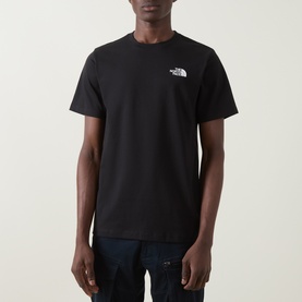Model wearing North Face Evolution Box Logo Back Graphic T-Shirt in black, crew neck, short sleeves, small logo on chest.
