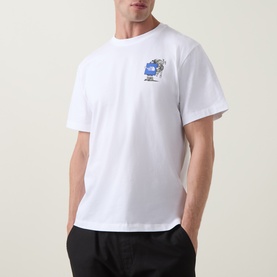Model wearing North Face white cotton crew neck T-shirt with small blue globe graphic print on chest, styled with black trousers.