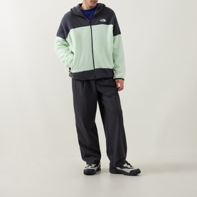 Model wearing North Face Calcified Lime and Anthracite zip-up fleece hoodie, styled with matching dark tracksuit trousers and white trainers.