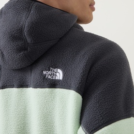 Model wearing The North Face fleece hoodie in Calcified Lime and Anthracite colourblock, with logo badge detail on back shoulder.