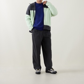 Model wearing North Face fleece in Calcified Lime/Anthracite colourblock, styled with navy knit, dark trousers and grey trainers.