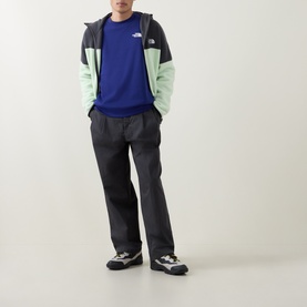 Model wearing North Face Bold Blue sweatshirt, styled with a colour-block windbreaker jacket and dark grey trousers.