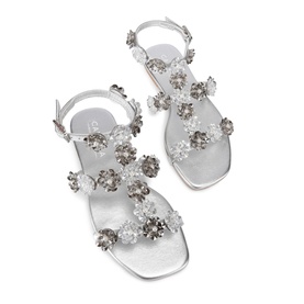 Silver flat sandals with crystal and clear gem flower embellishments across toe strap and ankle buckle fastening