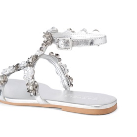 Silver flat sandal with crystal and floral embellishments, ankle buckle strap, and natural tan insole, angled rear view