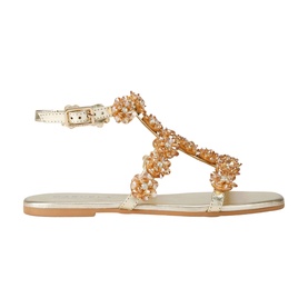 Carvela gold flat sandal with embellished floral bead T-bar strap, ankle buckle fastening, and tan sole.