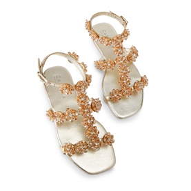Carvela gold flat sandals with floral crystal embellishments across straps, ankle buckle fastening, and ivory sole.