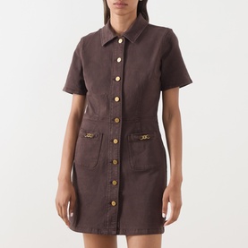 Model wearing Paige dress in Rich Chocolate, short-sleeve denim style with gold button placket and front patch pockets with gold chain detail.