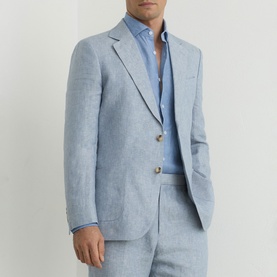 Model wearing Reiss soft blue linen suit jacket with gold buttons, styled with matching trousers and open-collar blue shirt