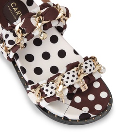 Capri sandals in white and brown polka dot fabric with gold chain straps, pearl and charm details, and black studded sole