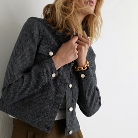 Model wearing Reiss blue textured jacket with gold snap buttons, styled with khaki trousers and a gold chain bracelet