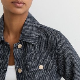Model wearing Reiss blue textured tweed jacket with gold-tone buttons and chest pockets, styled over white top