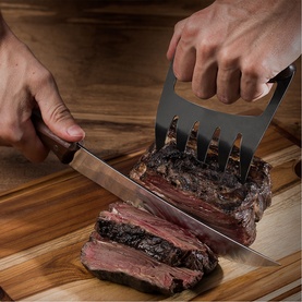 Tramontina stainless steel carver knife and meat claws in use slicing cooked brisket on a wooden chopping board