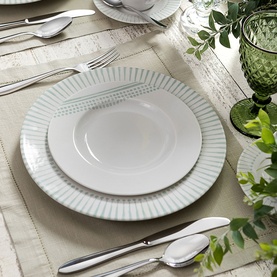 Tramontina white dinner set with ribbed detailing, styled with silver cutlery and green glassware on a linen tablescape