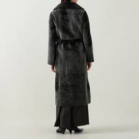 Model wearing Yves Salomon Long Belted Grey Shearling Coat, rear view, styled with a black maxi skirt