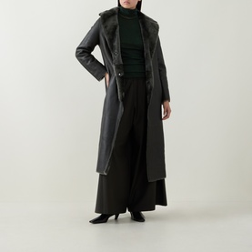 Model wearing Yves Salomon Long Belted Grey Shearling Coat, styled with black wide-leg trousers and a dark green turtleneck