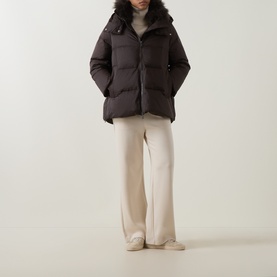 Model wearing Yves Salomon cold brew puffer jacket with fur-trimmed hood, styled with cream wide-leg trousers and cream trainers