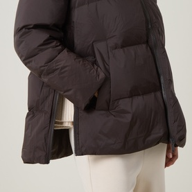 Model wearing Yves Salomon cold brew puffer jacket, close-up of side pocket and zip detail, styled with cream trousers