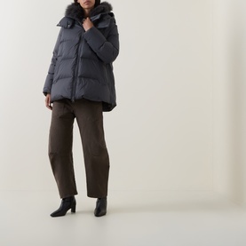 Model wearing Yves Salomon grey padded jacket with fur-trimmed hood, styled with brown wide-leg trousers and black heeled boots