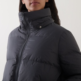 Model wearing Yves Salomon grey padded down jacket, close-up detail of high funnel neck, zip fastening and snap collar stud.