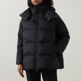 Model wearing Yves Salomon A-Line Down Jacket in black with removable hood, front zip fastening and press-stud pockets, styled with black trousers
