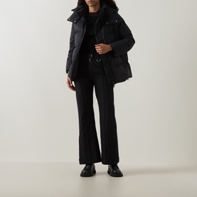 Model wearing Yves Salomon A-Line Down Jacket in black with high neck, styled with black wide-leg trousers and black loafers