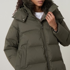 Model wearing Yves Salomon herbal tea quilted down jacket with faux fur-trimmed hood, zip fastening, close-up detail view