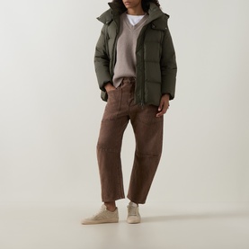 Model wearing Yves Salomon herbal tea hooded puffer jacket, styled with brown tapered trousers and cream trainers.