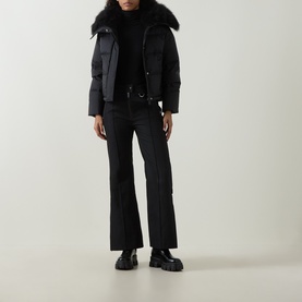 Model wearing Yves Salomon Cropped Down Jacket in black with removable shearling collar, styled with flared trousers and chunky black boots.