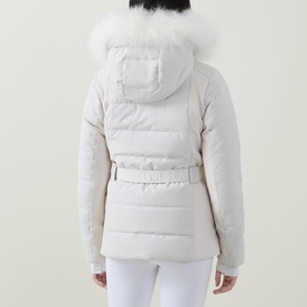 Model wearing Yves Salomon Fur-Trim Padded Ski Jacket in Mont Blanc, rear view, with white fur-trimmed hood, belted waist, styled with white ski