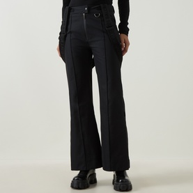 Model wearing Yves Salomon Salopettes Flared-Leg Ski Trousers in black with exposed seam detailing, styled with black top and chunky boots