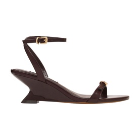 Steve Madden brown patent leather wedge sandals with sculptural heel, ankle strap and gold buckle detail, white sole.