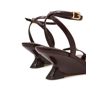 Steve Madden brown patent leather strappy sandals with sculptural flared heel, ankle strap and gold buckle detail, rear view
