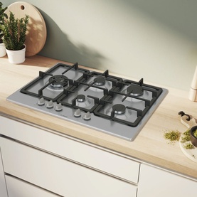 Bosch silver gas hob with four burners and cast iron pan supports, set into a light wood kitchen worktop