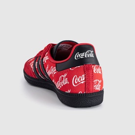 Adidas x Coca-Cola Samba trainer in red with all-over Coca-Cola script print, black three stripes, and black sole.
