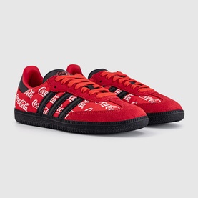 Adidas Samba sneakers in red with black three-stripe detailing and allover Coca-Cola script print, black rubber sole.