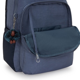 Kipling Game Grey backpack close-up showing open front flap pocket with zip compartment and teal monkey keyring charm.