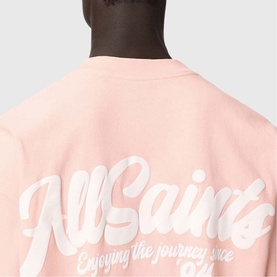 Model wearing All Saints Odyssey Oversized Bubble Logo T-Shirt in Blushed Pink, showing back bubble logo graphic detail