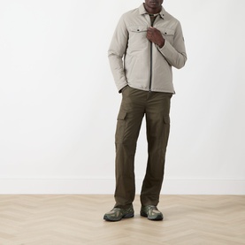 Model wearing Barbour International concrete casual jacket with chest pockets, styled with khaki cargo trousers and dark trainers.