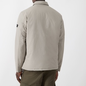 Model wearing Barbour International casual jacket in concrete, rear view showing sleeve badge detail, styled with olive trousers