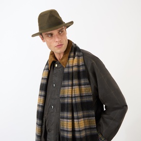 Model with Barbour Crayton Waxed Safari Hat in olive, styled with a plaid scarf and dark waxed jacket