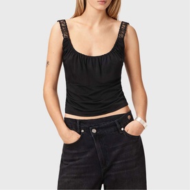 Model wearing All Saints Celena Logo Strap Top in black with lace straps and scoop neckline, styled with dark jeans.