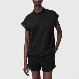 Model wearing All Saints Lele Lace Trim Top in black with lace trim neckline and hem, paired with matching black lace-trim shorts.