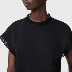 Model wearing All Saints Lele Lace Trim Top in black, featuring scalloped lace trim at neckline and cap sleeves, close-up detail shot.
