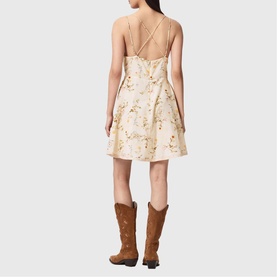 Model wearing All Saints Claire Floral Mini Flared Dress in caramel off-white with digital floral print, cross-back straps, styled with tan cowboy
