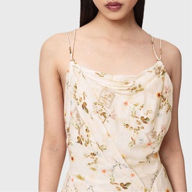 Model wearing All Saints Claire Floral Mini Flared Dress in caramel off-white with cowl neckline, adjustable double straps and gold 'D' ring hardware